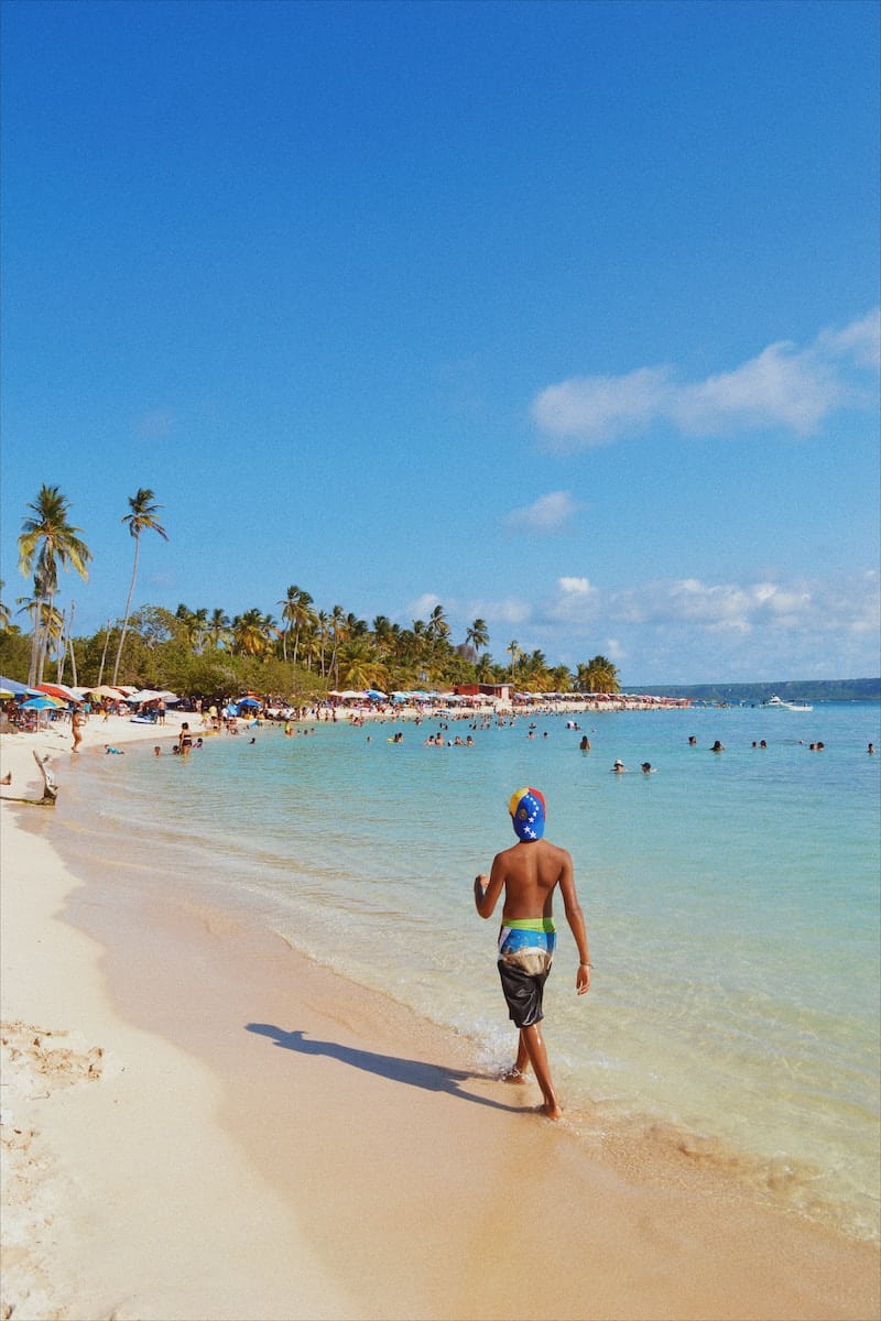 woman in blue bikini walking on beach during daytime